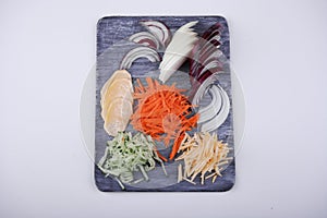 The cook cuts vegetables on a board. the ingredients are beautifully laid out - onion