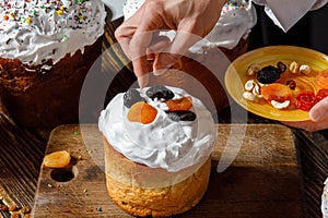 Cook decorates Easter cake with dried fruits photo