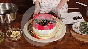 Cook is demonstrating her finished cake with red and black berries