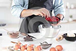 A cook with eggs on a rustic kitchen against the background of men`s hands