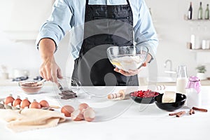 A cook with eggs on a rustic kitchen against the background of men`s hands