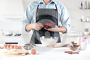 A cook with eggs on a rustic kitchen against the background of men`s hands