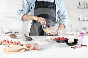 A cook with eggs on a rustic kitchen against the background of men`s hands