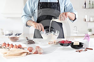 A cook with eggs on a rustic kitchen against the background of men`s hands