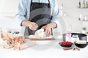 A cook with eggs on a rustic kitchen against the background of men`s hands