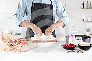 A cook with eggs on a rustic kitchen against the background of men`s hands