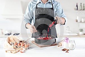 A cook with eggs on a rustic kitchen against the background of men`s hands