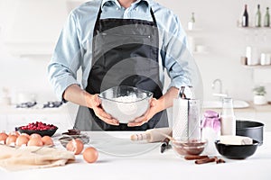 A cook with eggs on a rustic kitchen against the background of men`s hands