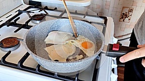 Cook flips the fried eggs in the pan on the kitchen