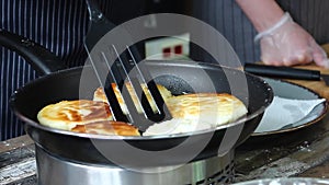 The cook flips pancakes stick to the pan