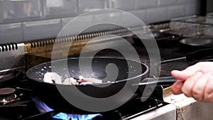 Cook frying seafood and shrimps in a pan