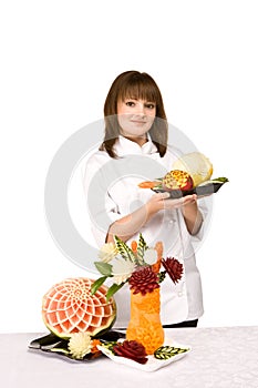 Cook girl holding a plate of fruit