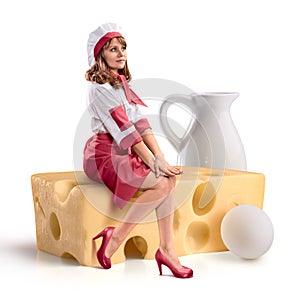 Cook girl sitting on a piece of cheese on isolated background photo
