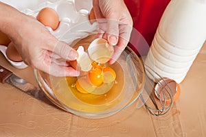 Cook hands adds eggs into dish
