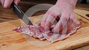 Cook hands cutting bacon. Food, slice.