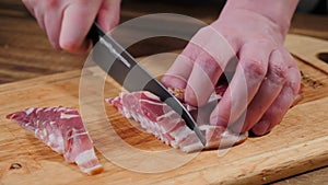 Cook hands cutting bacon. Food, slice.