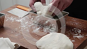 The cook hands form the dough and place it in the pan. the cook kneads the dough