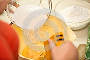 Cook hands pouring sugar into bowl