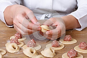 Cook hands sculpt dumplings with minced meat photo