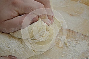 Cook kneads pizza dough with his hands