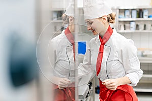 Cook in large commercial kitchen stirring sauce