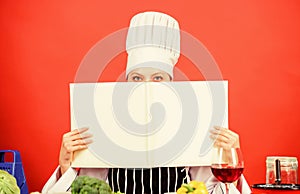 Cook looking for cooking recipe in cookbook. Woman reading cook book in kitchen. Girl cook at kitchen table ingredients