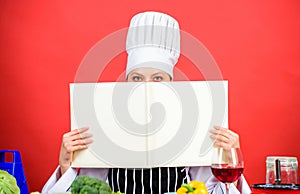 Cook looking for cooking recipe in cookbook. Woman reading cook book in kitchen. Girl cook at kitchen table ingredients