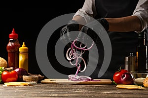 Cook marinates a red onion for a burger, a burger recipe. A recipe for cooking, making a juicy hamburger, a menu, homemade recipes