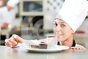 Cook, pastry chef, in hotel or restaurant kitchen photo