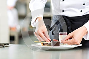 Cook, pastry chef, in hotel or restaurant kitchen photo