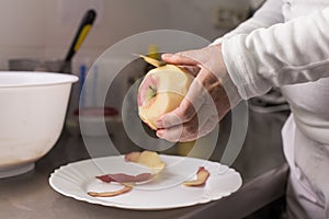 Cook peeling apples in the kitchen