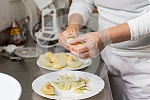 Cook peeling apples in the kitchen