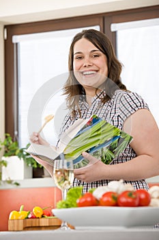 Cook - Plus size happy woman holding cookbook