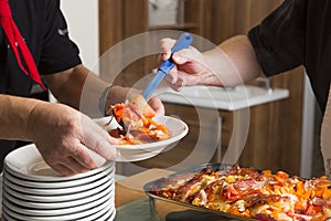 Cook is portioning the meal