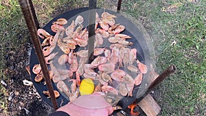 The cook pours shrimp on the grill with sauce. Close-up of king prawns frying in a frying pan. The chef is frying king