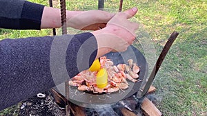 The cook pours shrimp on the grill with sauce. Close-up of king prawns frying in a frying pan. The chef is frying king