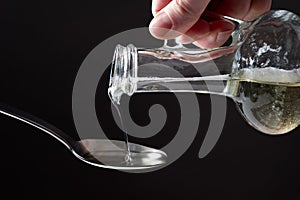 The cook pours sunflower oil and glass bottles into a spoon