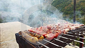 The cook prepares barbecue in the village. Pork meat on fire. Red tomatoes, yellow shorties and pork meat on the fire. Flight dish