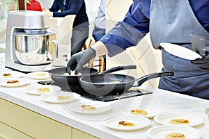 Cook prepares cheesecakes syrniki in frying pan