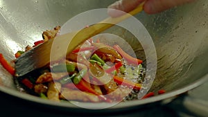 Cook prepares in a frying pan, in oil, with fresh vegetables - potatoes, tomatoes, green beans