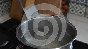 Cook prepares the Georgian national food of Khinkali. Khinkali in boiling water in close-up.