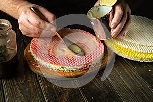 The cook is preparing a delicious waffle cake with jam and condensed milk for a festive dinner. Vintage spoon in chef hand