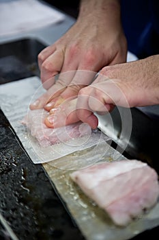 cook preparing fish meat