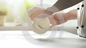 Cook preparing fresh pizza and kneading the dough