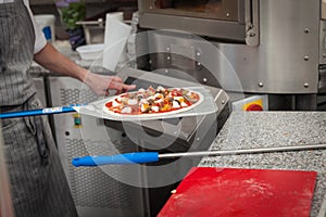 cook pulls lave baked pizza