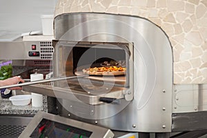 cook pulls lave baked pizza