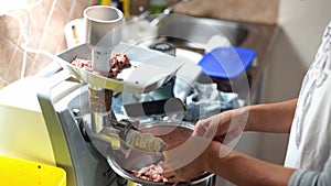 Cook puts on an intestine for stuffing sausage in a meat grinder