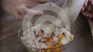 Cook puts sauce on salad close-up