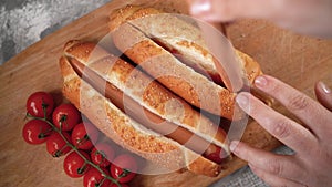 the cook puts sausage in a hot dog bun. Fast food, recipe,