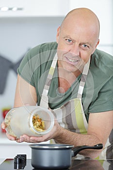 cook putting pasta into boiling water